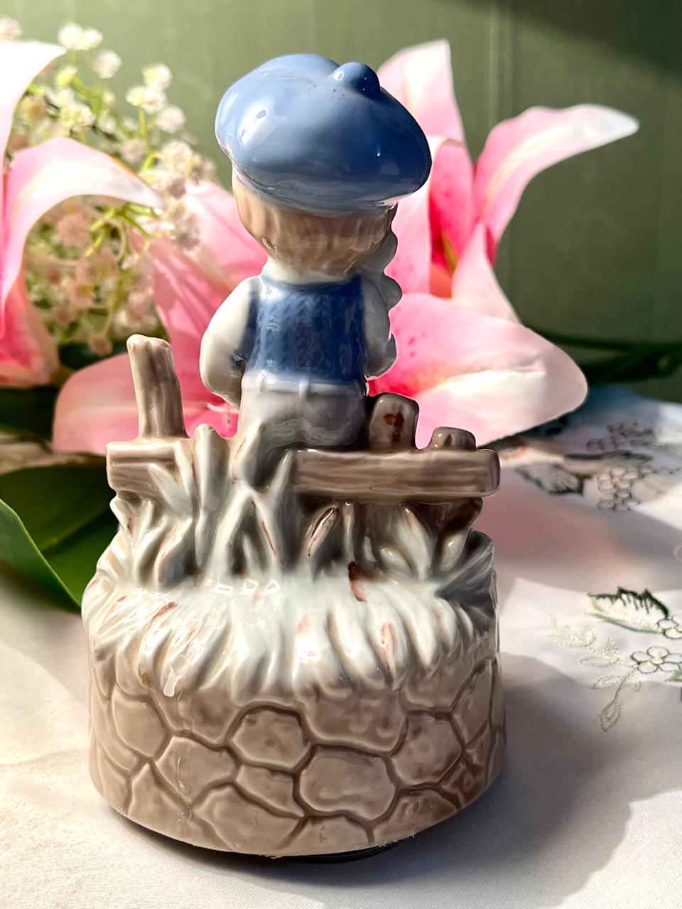 Vintage Porcelain Boy Figurine Musical on Stone Wall Base with Blue Cap Approx. 15 cm