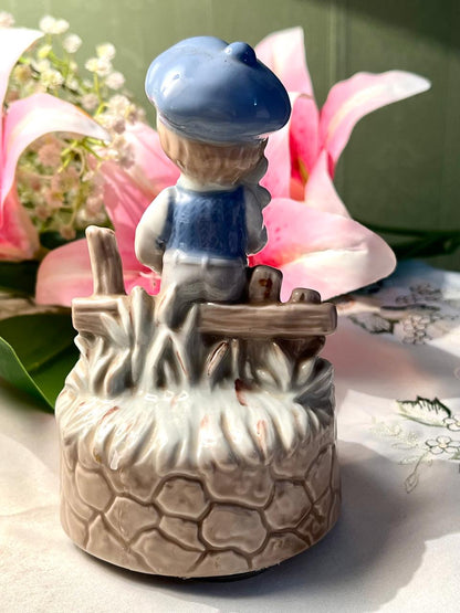 Vintage Porcelain Boy Figurine Musical on Stone Wall Base with Blue Cap Approx. 15 cm
