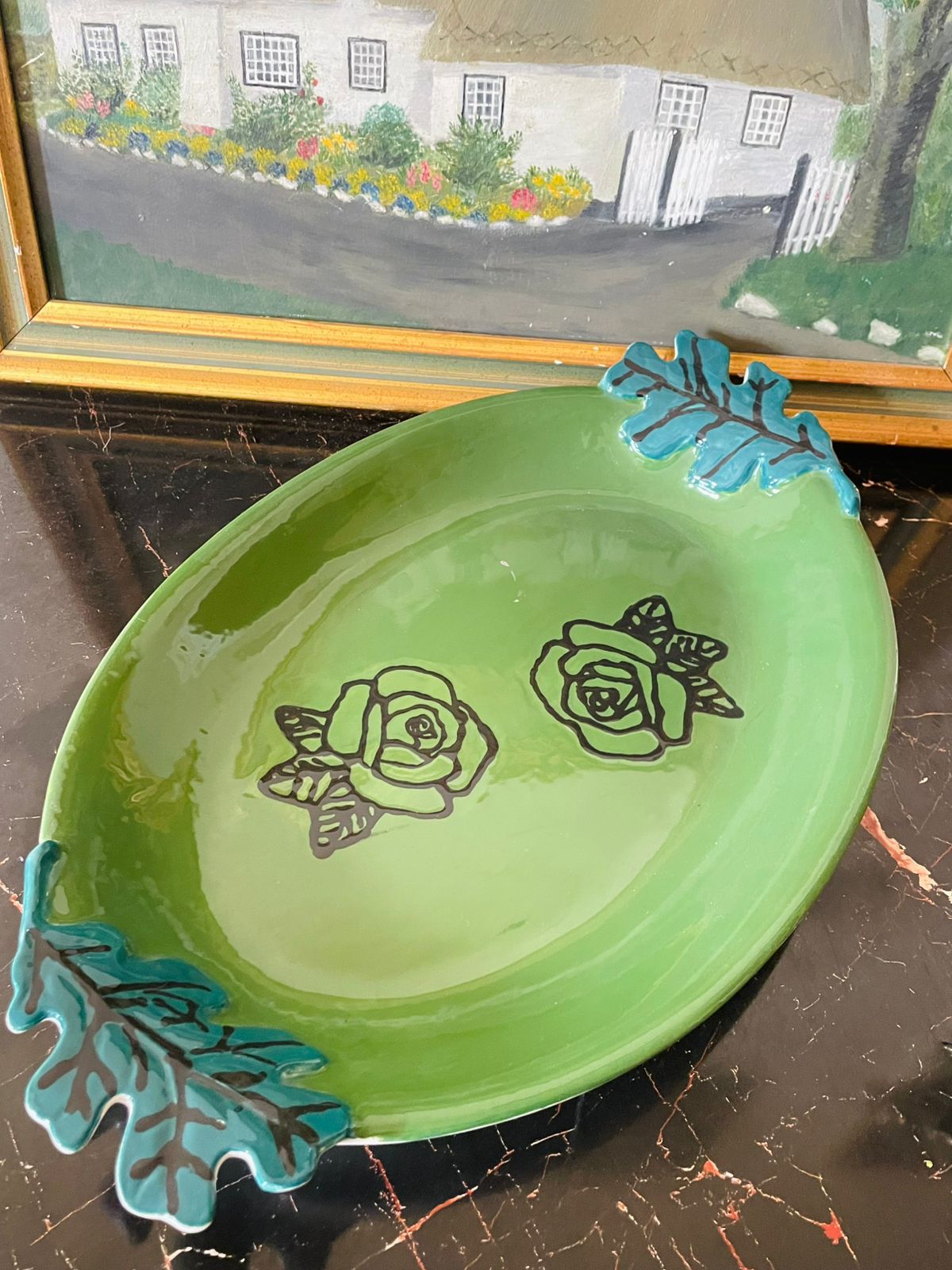 green ceramic platter, mid century modern pottery, hand painted serving dish, retro ceramic decor, artisan tableware, floral motif dish, vintage kitchenware, turquoise handles, unique ceramic art, collectible serving platter, handmade pottery
