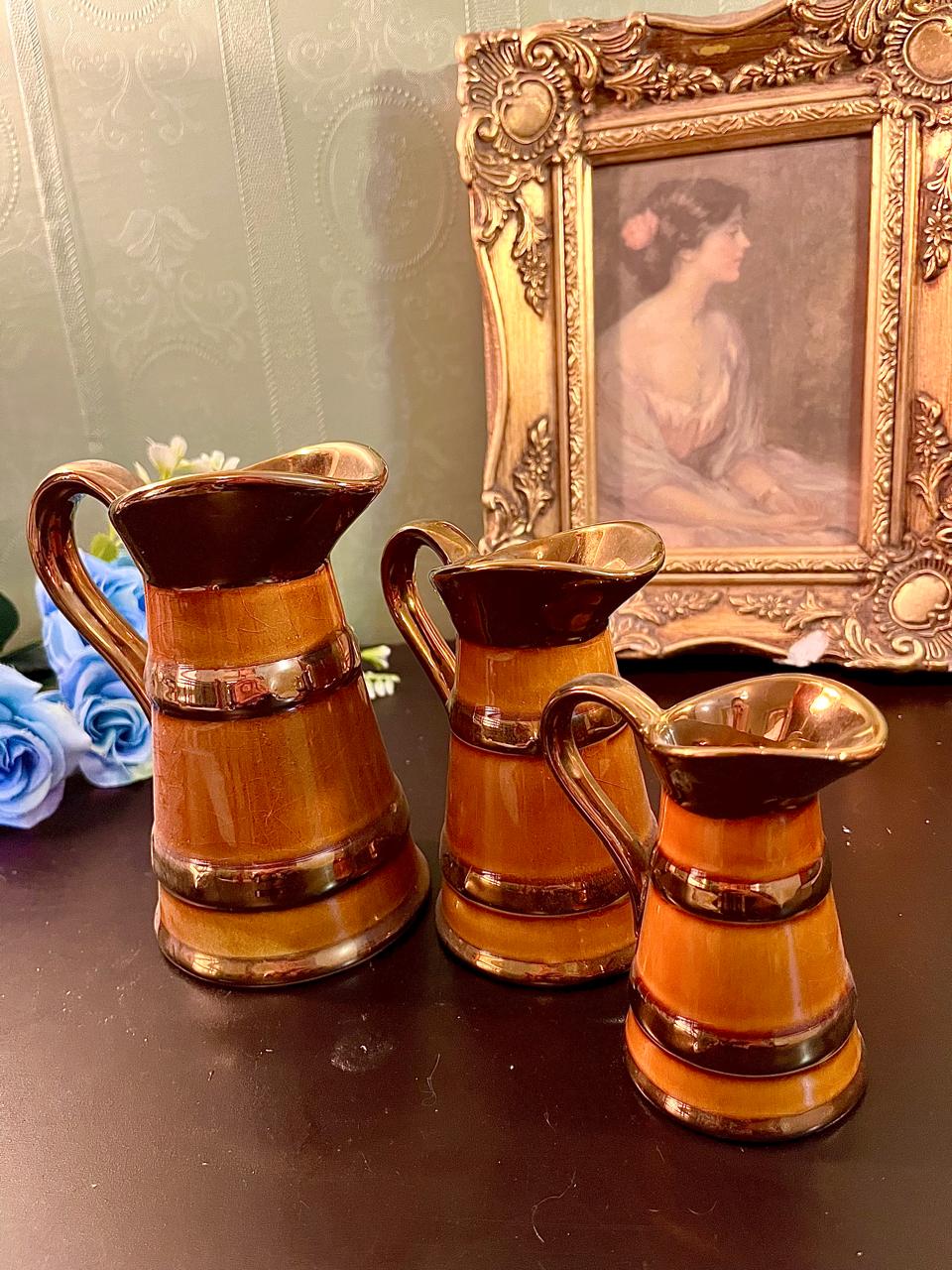 Set of three graduated Lord Nelson Pottery amber jugs