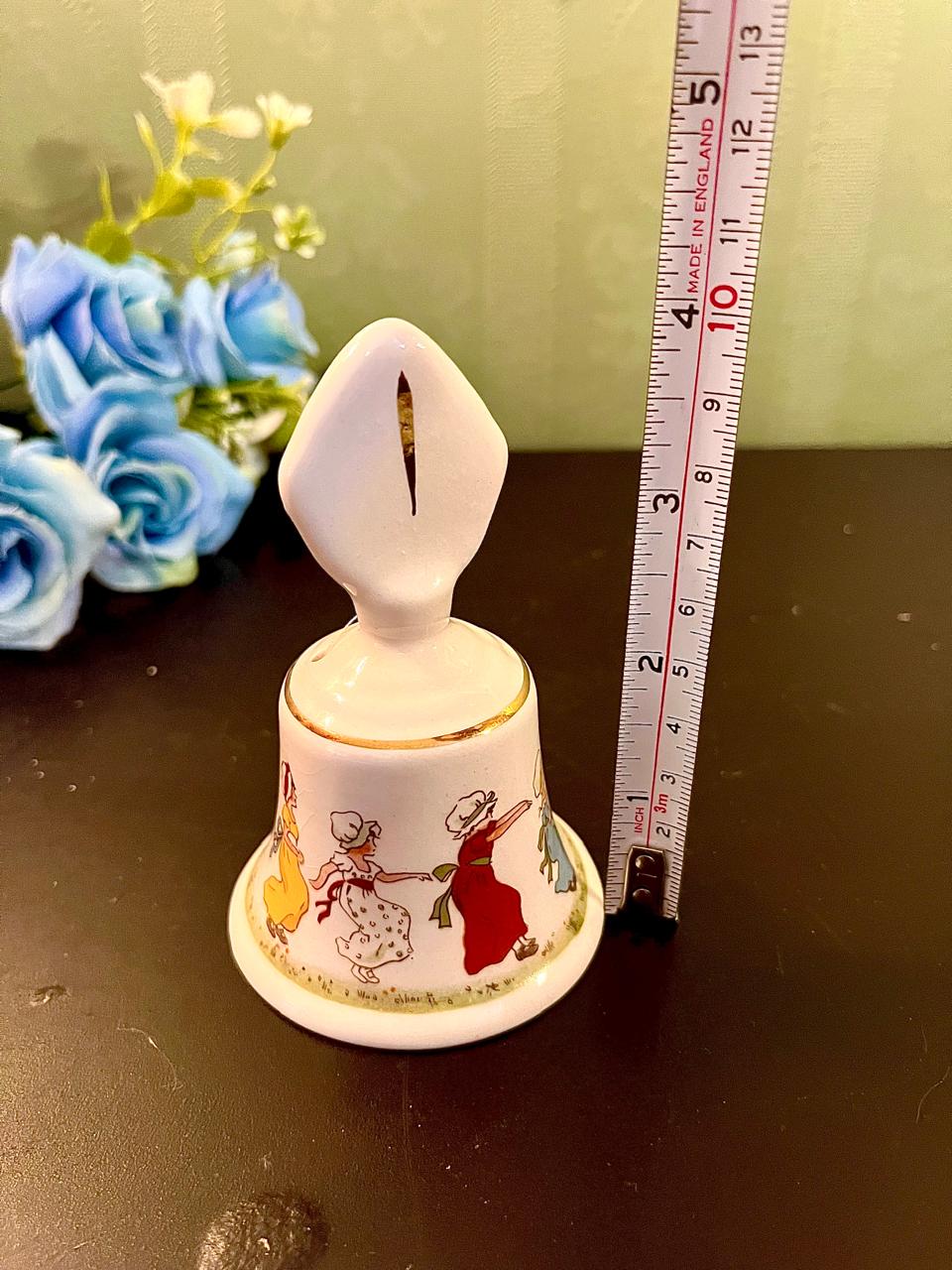 Nursery rhyme bell with ruler showing approximately 5.5 inch height