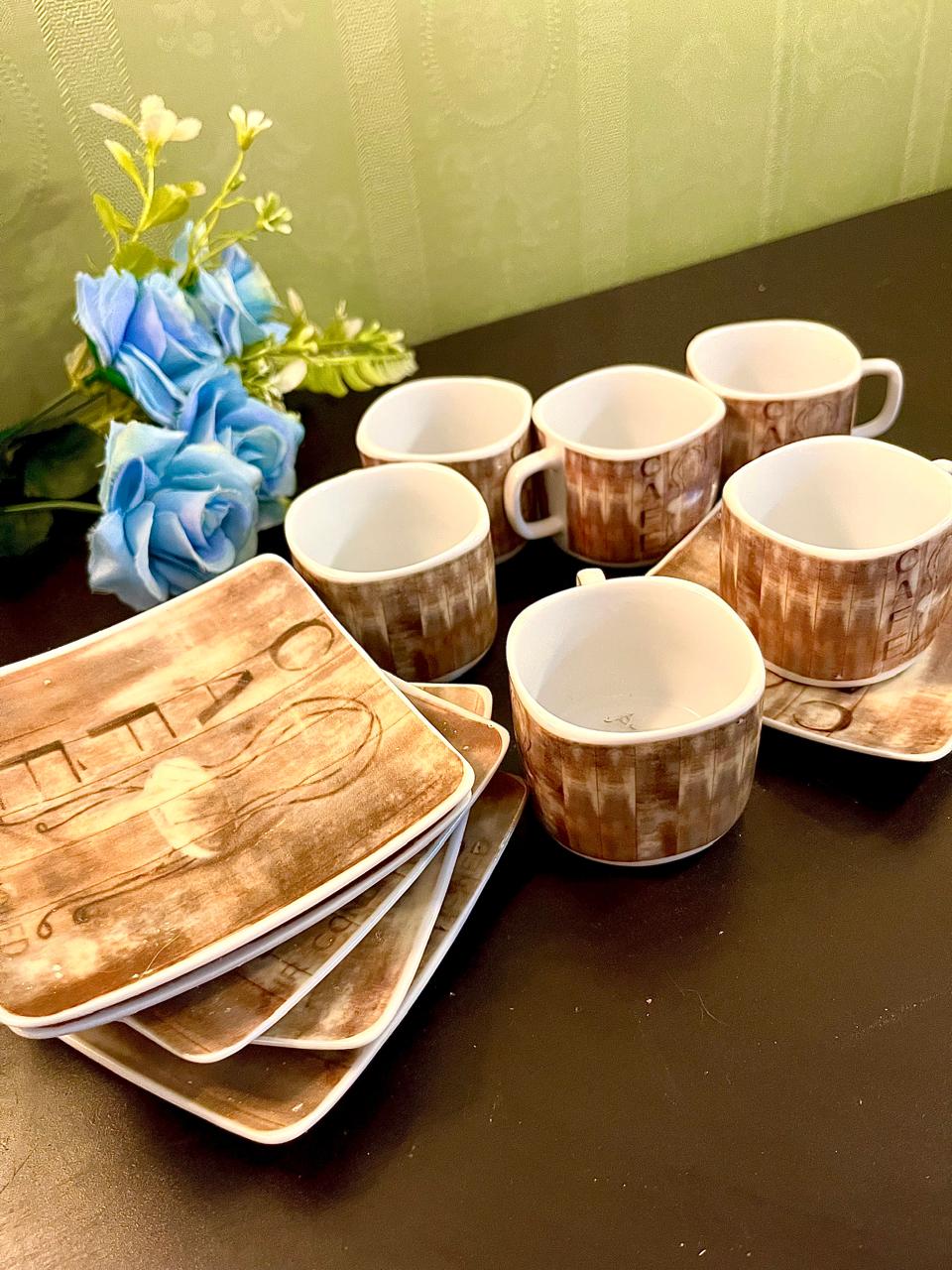 CAFE cups and square saucers arranged on table