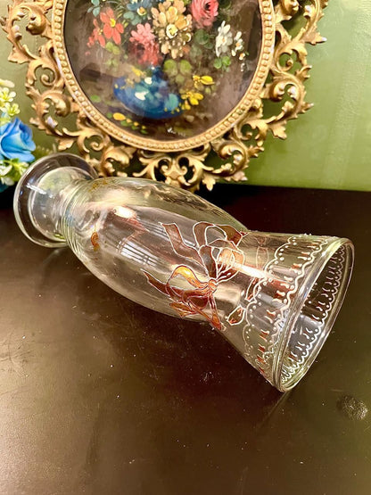 Glass vase laid on its side showing footed base and painted ribbon detail