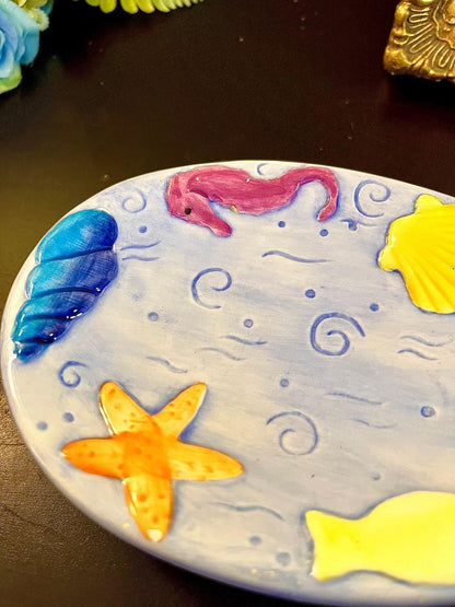 Vintage pastel sea creature ceramic plate with ruler showing approximate size