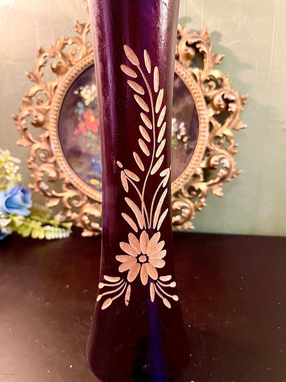 Close-up of gold etched daisy and leaf motif on purple glass