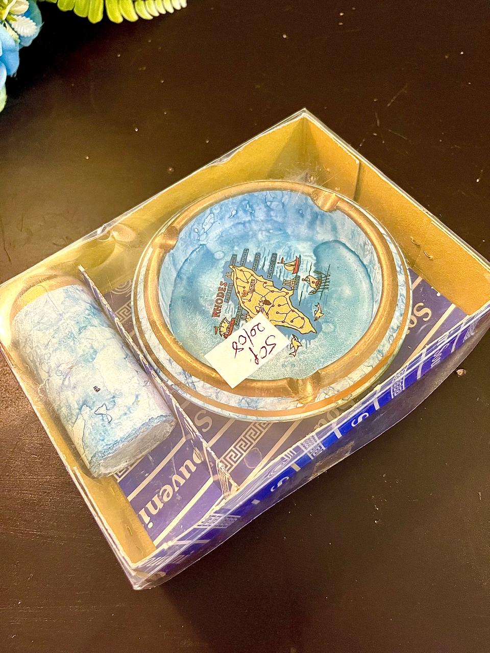 Boxed vintage souvenir ashtray and cylinder set, gold rim with island map motif