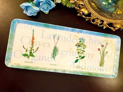 Rectangular tray with botanical herb illustrations labeled Agrimony Lavender Oregano Chives