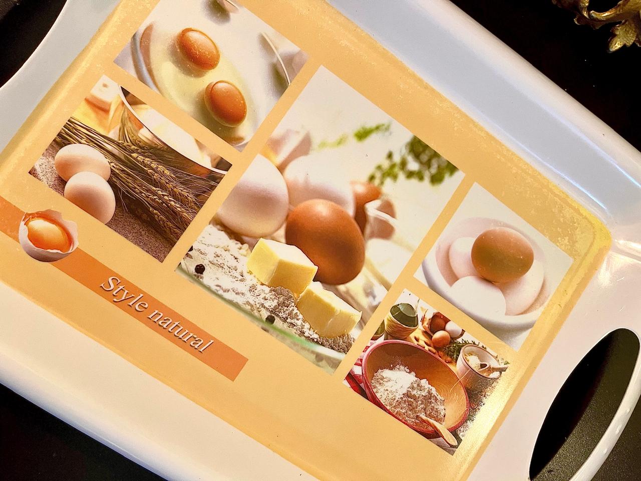 Close-up of eggs, flour, and butter collage print on tray