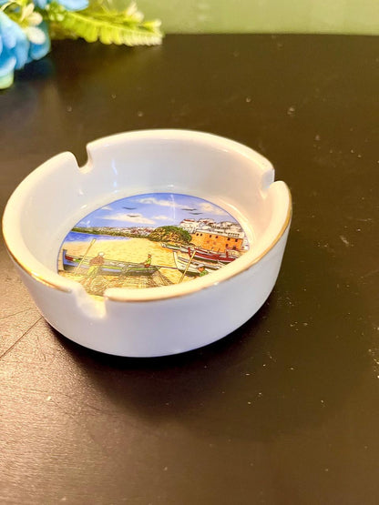 Close-up of hand-painted harbor scene on vintage ceramic ashtray