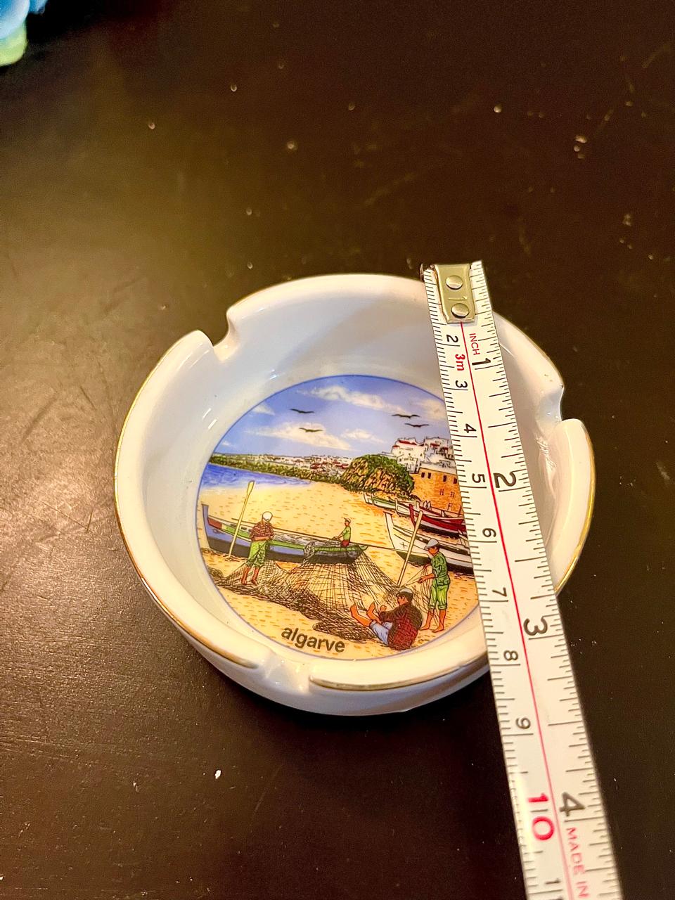 Vintage ceramic ashtray with ruler showing approximate 4 inch diameter