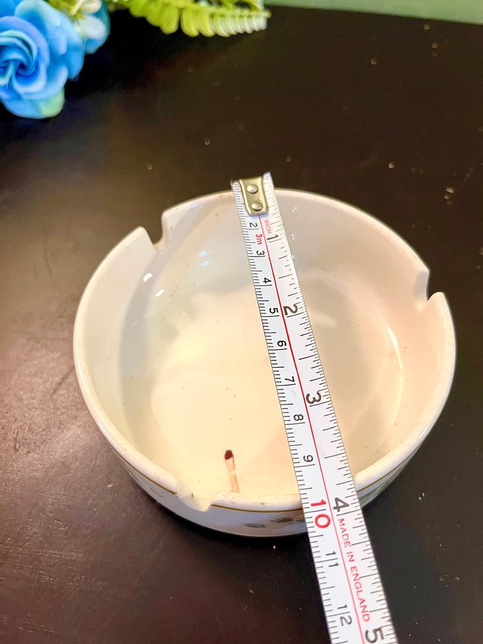 Vintage plain cream ceramic ashtray with ruler showing approximate 4 inch diameter