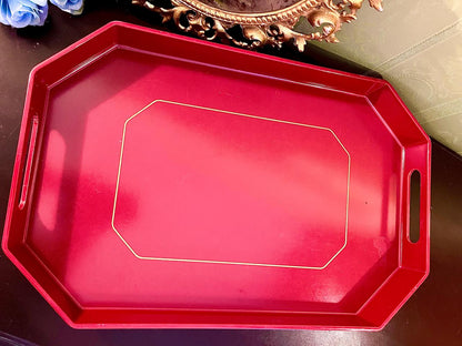 Red glossy octagonal serving tray with gold trim line and cut-out handles