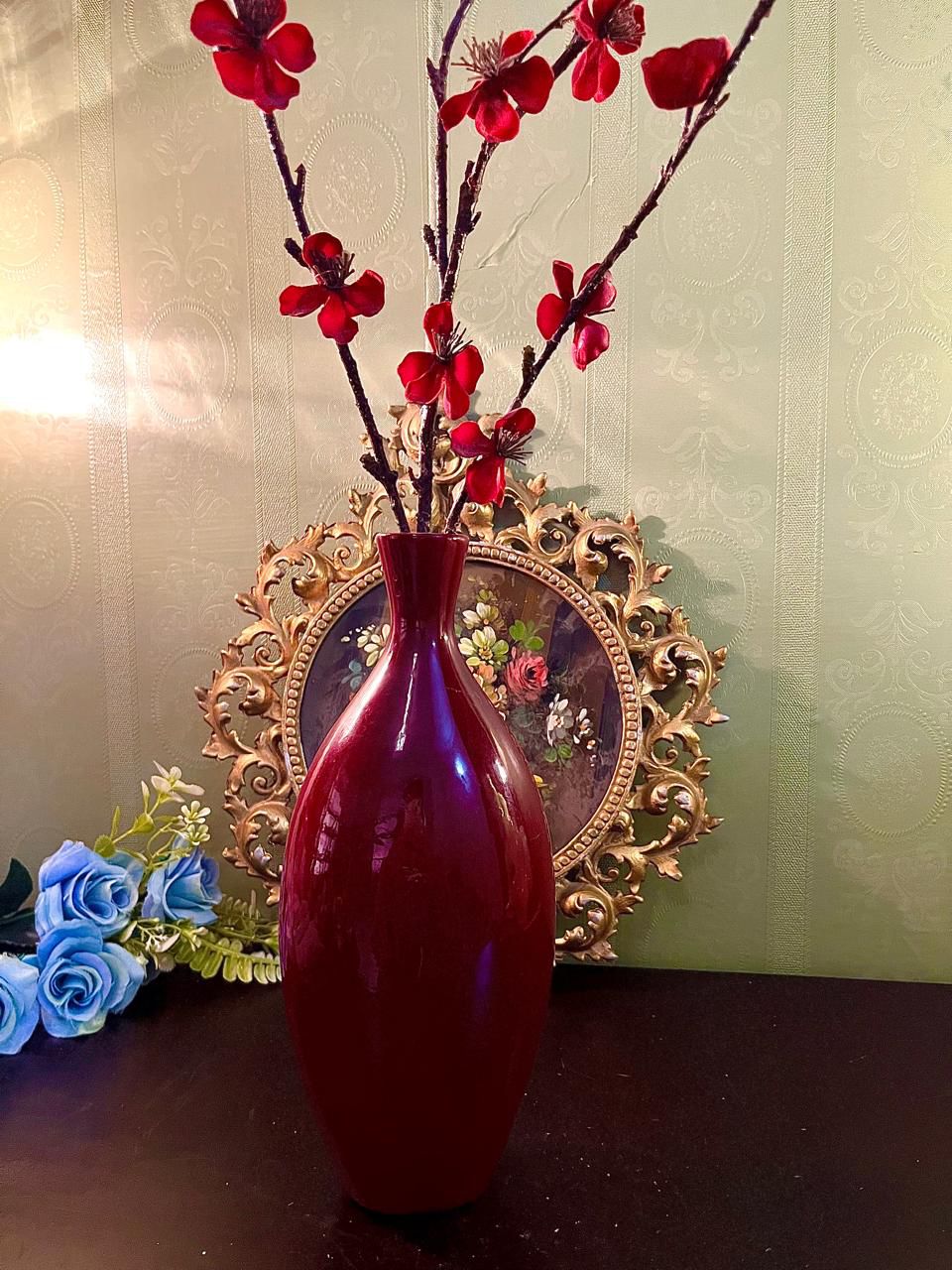 Burgundy ceramic bud vase with red faux blossom branches