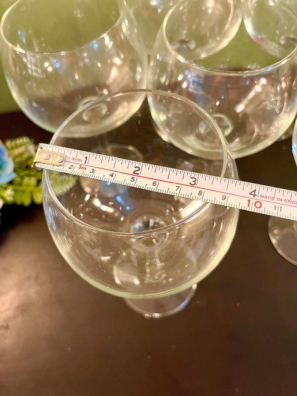 Wine glass rim with ruler showing approximately 3.5 inch diameter
